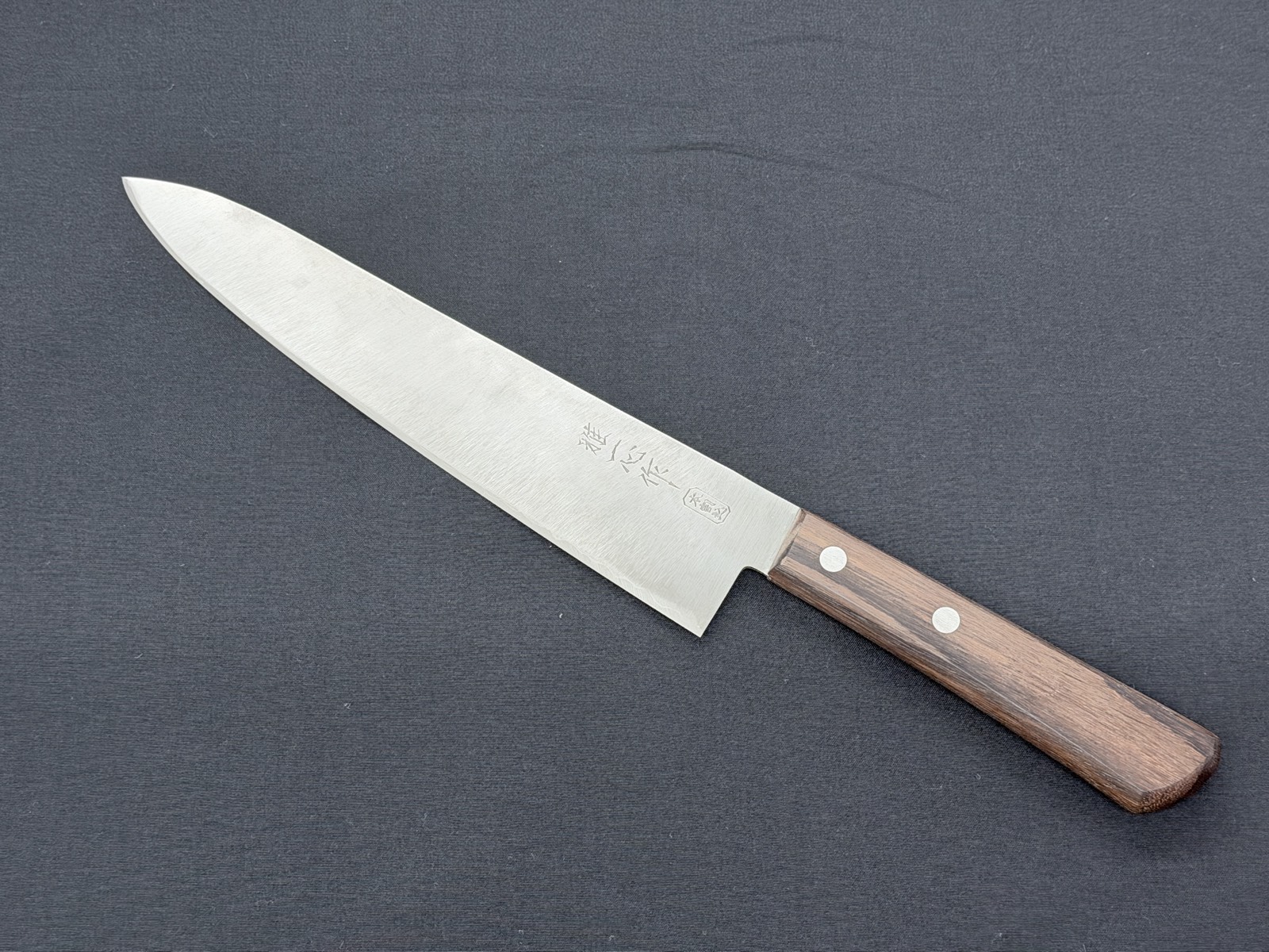 A santoku sharpened at Tsubaya, with even the scratches on the blade face faded away and the knife beautifully restored